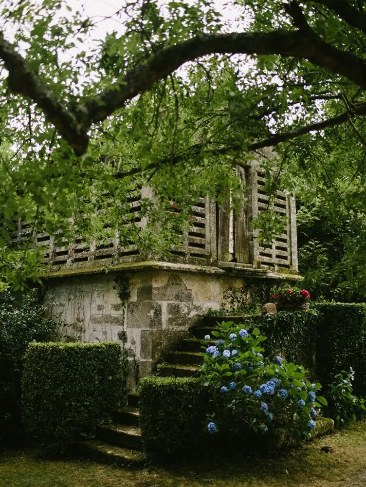 Escalinata del Pazo de Sergude rodeada de vegetación y vistas al valle.