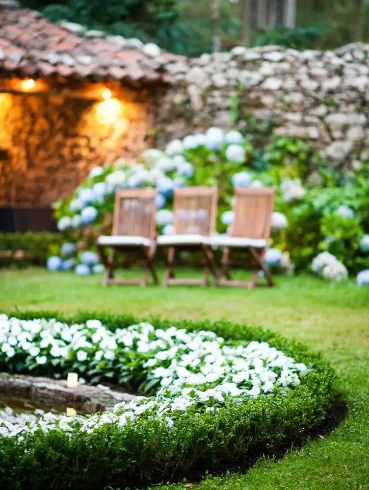 Rincón del jardín del Pazo de Sergude iluminado para eventos al atardecer.